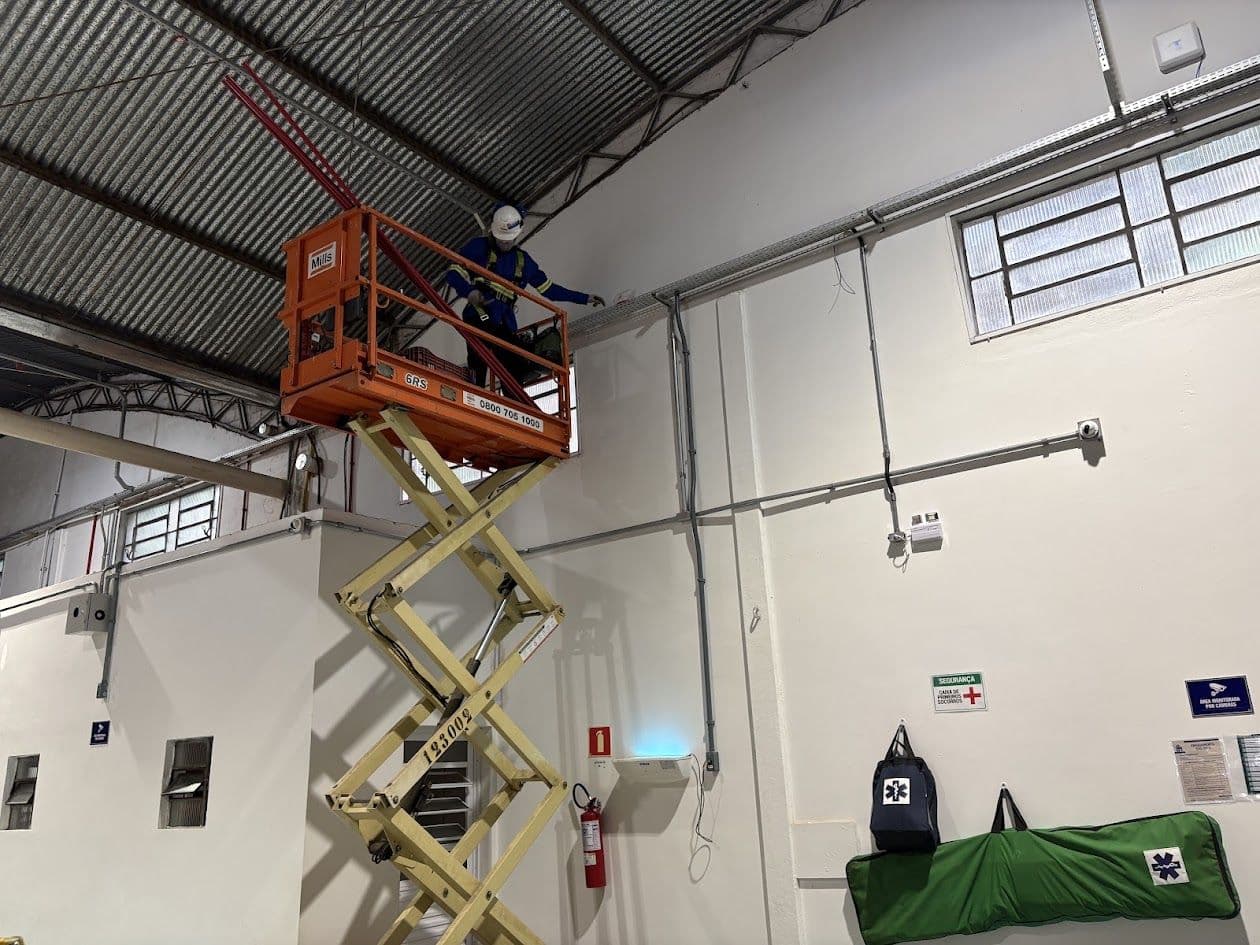 Equipe da Spaki em plataforma elevatória instalando o sistema em um galpão